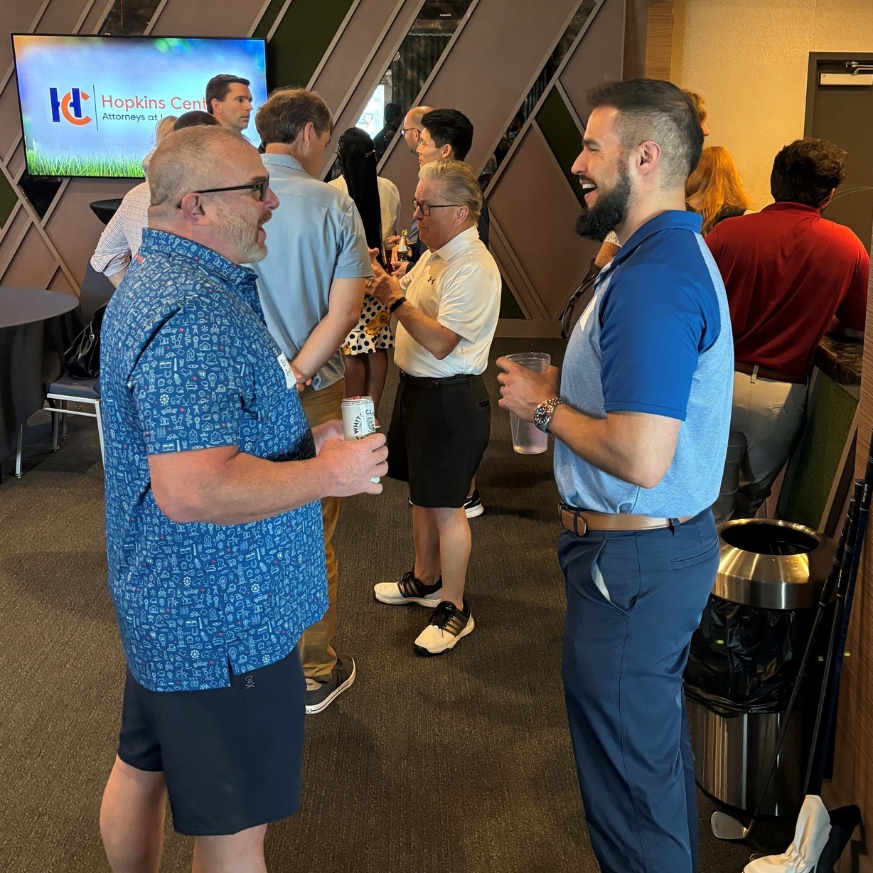 Two men smiling and chatting during a social networking event