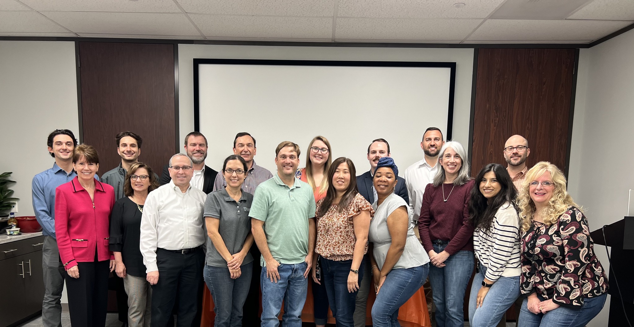 Group of professionals smiling for a team photo in an office conference room